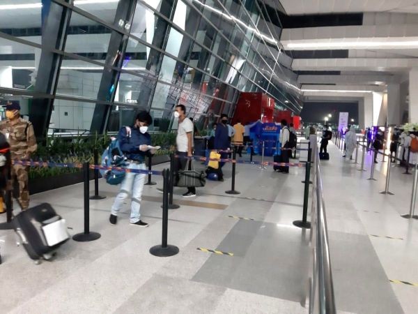 Passengers follow social distancing norms at they enter Indira Gandhi International Airport via Terminal 3 after India resumed civil passenger flight services on Monday. (IANS Photo)